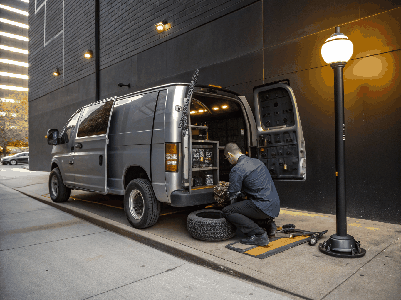 Technician using hydraulic mounting machine inside mobile service van on location